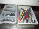 two trays with utensils and spoons in them