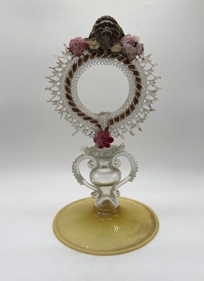 a small mirror on a stand with a bird on it
