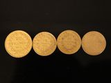 quatre types différents de pièces d'or sur une surface noire