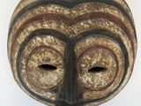 une image d'un masque en bois sur fond blanc