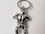 a silver keychain that has a silver teddy bear on it