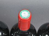 three bottles of red wine sitting on top of a table
