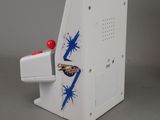 a small toy arcade machine with a red ball on top of it
