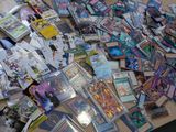 a pile of pokemon cards on a table next to a laptop