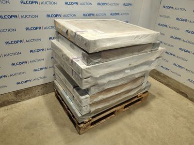 une pile de matelas posée sur une palette devant un mur