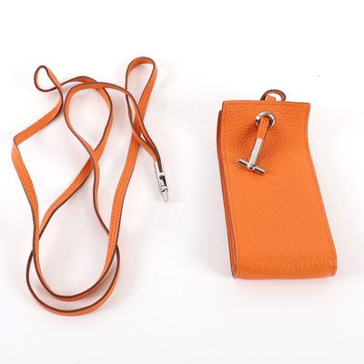 une coque de téléphone portable orange à laquelle est attachée une lanière