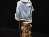 figurine of a man sitting on a stool with a dog