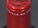 a bottle of wine that has a red cap on it