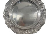 a silver plate with a design on it on a white background