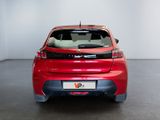 the rear end of a red car in a room with a white wall
