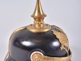 an old helmet with a gold decoration on the top of it