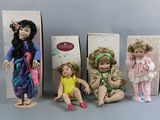 three boxed dolls of children sitting next to each other on a table