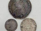 three silver coins, one of which has a crown and one of which has a crown on it