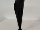 a black vase sitting on a table with a white background