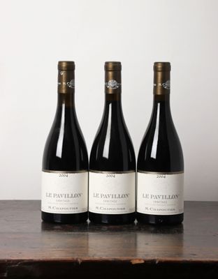trois bouteilles de vin posées sur une table en bois