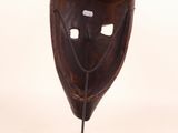 an image of a wooden mask on a stand on a white background