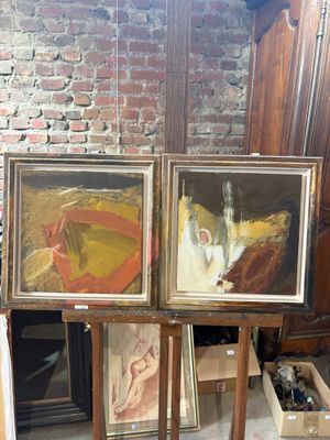 three paintings on easels in a room with a brick wall