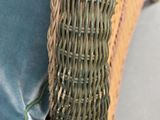 a close up of a wicker chair with a blue cushion