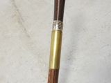a wooden stick with a metal handle on a white cloth