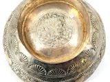 an antique silver plate with a floral design on the rim