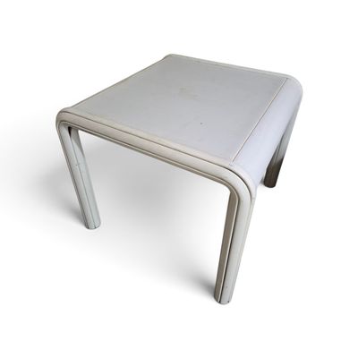 une petite table blanche surmontée d'un piètement métallique