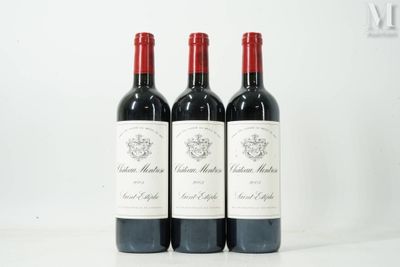 Trois bouteilles de vin rouge sont alignées sur une table blanche