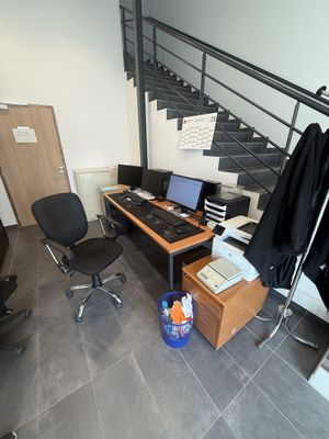 un bureau avec un ordinateur et une chaise dans une pièce