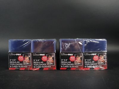trois paquets de papier photo Ultra Pro posés sur une surface noire
