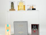 trois flacons de parfum et une boîte de parfum sur une étagère