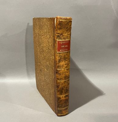 an old book sitting on top of a white surface