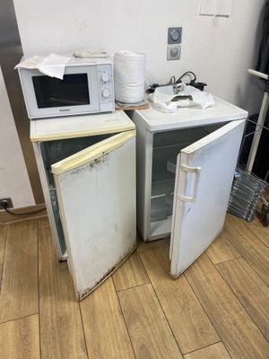 deux petits réfrigérateurs et un micro-ondes posés sur un parquet
