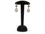 a close up of a pair of earrings on a stand
