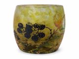a yellow vase with black flowers on it on a white surface