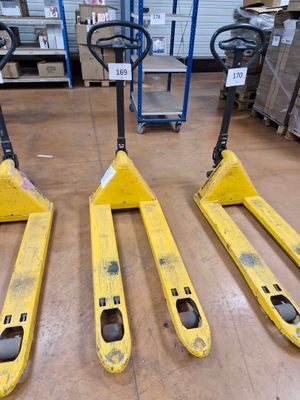 deux chariots élévateurs jaunes posés sur un plancher en bois dans un entrepôt