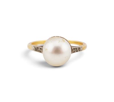a close up of a pearl and diamond ring on a white background