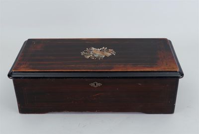 une petite boîte en bois dont le couvercle est orné d'un motif floral