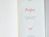 an open book with the title propos written in red on it