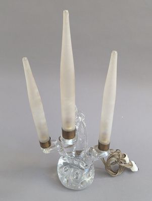 un bougeoir en verre contenant trois bougies