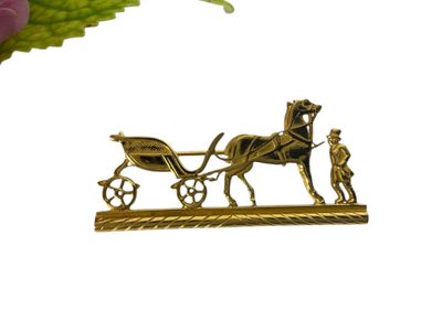 une broche en or représentant une calèche