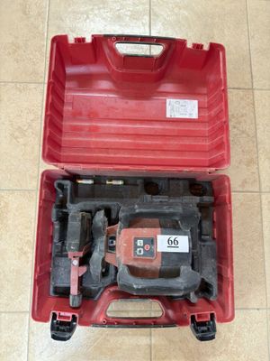 une image représentant une boîte à outils rouge contenant des outils, posée sur un sol carrelé