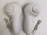 two wii controllers sitting on a white surface next to each other