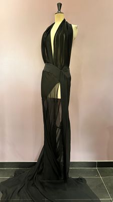 the back of a black dress with sheer panels on a mannequin