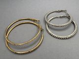 trois paires de boucles d'oreilles en forme d'anneaux, en or et en argent, posées sur un fond gris