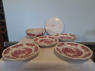 plusieurs assiettes et bols rouges et blancs posés sur une table