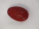 an image of a red carved object on a white surface