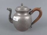 a silver teapot with a wooden handle on a grey background