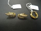 deux paires de boucles d'oreilles et un collier posés sur un fond noir