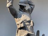 a statue of a man in a military uniform holding his hands up