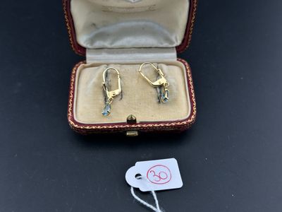a pair of earrings in a box with a price tag