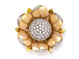 a gold and diamond flower broochle, by van cleef